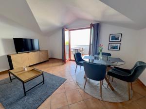 Una sala de estar con una mesa y sillas y un televisor. en Fažana INN, en Fažana