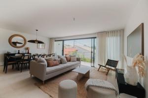 een woonkamer met een bank en een eetkamer bij Villa Cordouan avec piscine en bord de mer in Royan