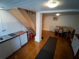 une cuisine avec un escalier et une salle à manger dans l'établissement Spreewälder Schwalbenhof - Ferienwohnung "Storchennest", à Golßen