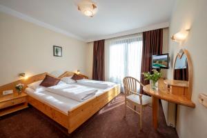 a hotel room with a bed and a table and a desk at Gasthof Feichter in Finkenstein