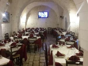a dining room with white tables and chairs and a window at Masseria Nzeta in Carovigno