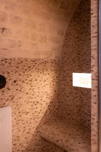 a bathroom with a brick wall and a ceiling at Masseria Auraterrae in Polignano a Mare