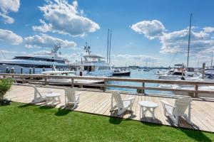 una terraza con sillas y barcos en un puerto deportivo en The Newport Harbor Hotel & Marina, en Newport