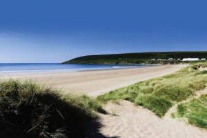 a view of a sandy beach with the ocean at Braunton Beach Boutique in Wrafton