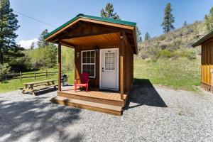 a small shed with a red chair and a bench at Echo Valley Resort + Cabins in Manson