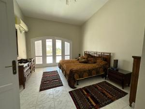 a bedroom with a bed and two rugs at Marina 7 4BR Villa lake view in El Alamein