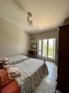 1 dormitorio con 2 camas y ventana en Marina 7 4BR Villa lake view en El Alamein