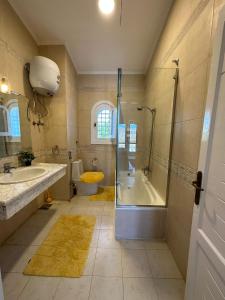 La salle de bains est pourvue d'une douche, d'une baignoire et d'un lavabo. dans l'établissement Marina 7 4BR Villa lake view, à El Alamein