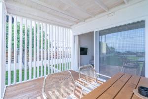 a porch with a wooden table and chairs on a balcony at Thea Eco Suites in Nea Kallikrateia