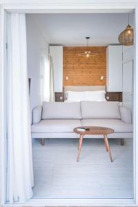 a living room with a white couch and a table at Thea Eco Suites in Nea Kallikrateia
