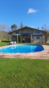 a swimming pool in front of a house at casa rural usko in Amurrio