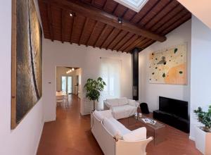 a living room with white furniture and a wooden ceiling at San Niccolò City Walls Garden in Florence