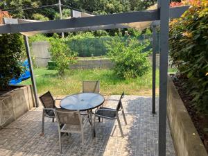 een patio met een tafel en stoelen en een parasol bij Cavone 1 in Castellare-di-Casinca