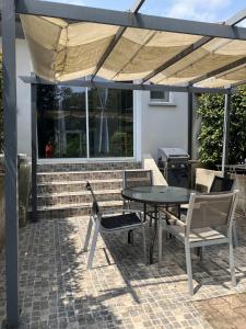 un patio con mesa y sillas bajo una sombrilla en Cavone 1 en Castellare-di-Casinca