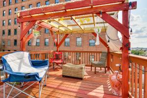 a wooden deck with chairs and a pergola at Quirky Baltimore Townhome about 2 Mi to Inner Harbor in Baltimore
