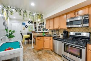 a kitchen with wooden cabinets and a stove top oven at Quirky Baltimore Townhome about 2 Mi to Inner Harbor in Baltimore
