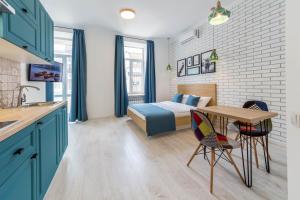 a bedroom with a bed and a table and a desk at DayFlat Apartments Olimpiyska Area in Kyiv