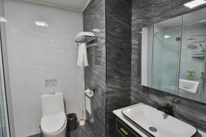a bathroom with a toilet and a sink and a mirror at TTI Hotel in Ulaanbaatar in Ulaanbaatar +54 photos