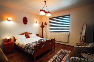 a bedroom with a bed and a window and a couch at Casa cu Elefanți in Corbşori