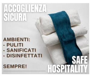 - une pile de serviettes avec une cravate au-dessus dans l'établissement Villetta Leccino Home tra Collina e Mare by Yohome, à Fiorenzuola di Focara
