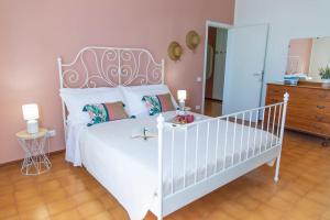 - une chambre avec un lit blanc et un berceau blanc dans l'établissement Villetta Leccino Home tra Collina e Mare by Yohome, à Fiorenzuola di Focara