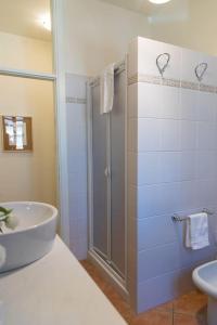 La salle de bains est pourvue d'une douche et d'un lavabo. dans l'établissement Villetta Leccino Home tra Collina e Mare by Yohome, à Fiorenzuola di Focara