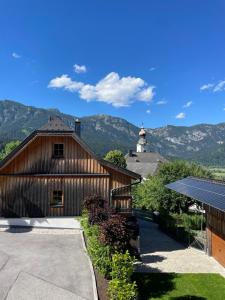 a barn with a solar roof with mountains in the background at Luserblick in Haus im Ennstal
