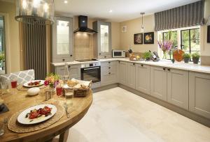 a large kitchen with a wooden table with food on it at Pink Cottage in Shifnal