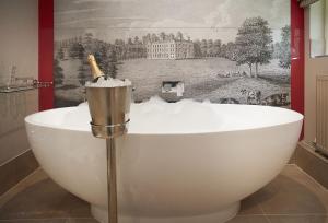 a bath tub with a champagne bottle in it at Pink Cottage in Shifnal