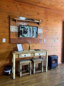 einen Holzschreibtisch mit zwei Hockern in einem Zimmer in der Unterkunft Pousada Costaneira in Cambará