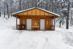 a wooden cabin with a desk in the snow at Echo Valley Resort + Cabins in Manson