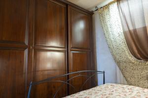 a bedroom with a large wooden cabinet next to a bed at Casa Ambra mare in Bordighera
