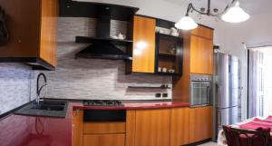 a kitchen with wooden cabinets and a red counter top at Casa Ambra mare in Bordighera +7 photos