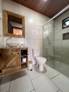 uma casa de banho com um WC, um lavatório e um chuveiro em Pousada Costaneira em Cambará