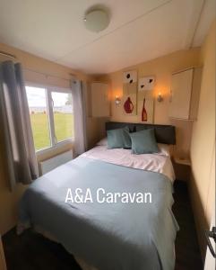 1 dormitorio con cama y ventana en A&A Caravan Holidays, en Leysdown-on-Sea