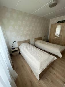 Duas camas num pequeno quarto com pisos em madeira em Linda apartment em Kuressaare