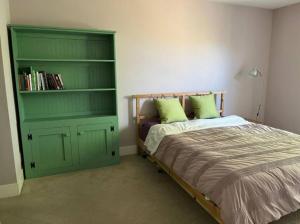 een slaapkamer met een bed en een groene kast bij Sunny 2 BR Condo Retreat with Awesome Water Views! condo in Richmond