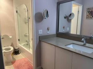 een badkamer met een wastafel, een toilet en een spiegel bij Sunny 2 BR Condo Retreat with Awesome Water Views! condo in Richmond
