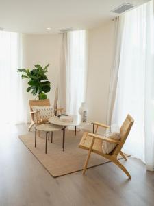 un soggiorno con 2 sedie e un tavolo di Retiro Costiña Wellness&villas a Santa Comba