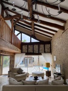 una sala de estar con sofás y una habitación grande con techos de madera. en Anahata Gite, en Constant