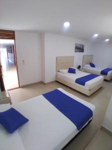 duas camas num quarto com azul e branco em Hotel San Fernandos Plaza em San Rafael