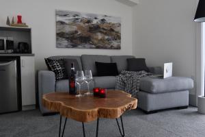 sala de estar con sofá y mesa con copas de vino en Destination Owl's Head - Mtn Haus, en Mansonville