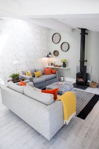 a living room with a gray couch with orange pillows at The Potting Shed in Shifnal