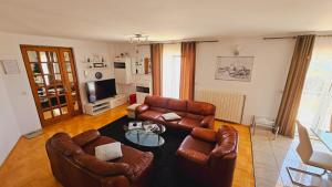 ein Wohnzimmer mit Ledermöbeln und einem Tisch in der Unterkunft Apartment house Berry in Primošten