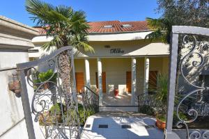 um portão para uma casa com uma palmeira em Villa Alba, Apartment Katja - with swimming pool em Ičići