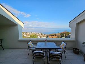 d'une table et de chaises sur un balcon avec vue sur l'océan. dans l'établissement Villa Alba, Apartment Katja - with swimming pool, à Ičići