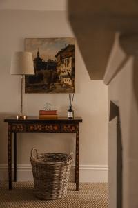 wiklinowy kosz siedzący obok stołu z lampą w obiekcie Plum Bray w mieście Bray
