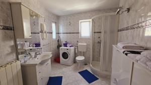 ein Badezimmer mit Waschbecken und Waschmaschine in der Unterkunft Apartment house Berry in Primošten