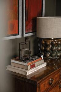 a stack of books sitting on a table with a lamp at Plum Bray in Bray