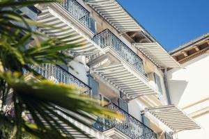 apartamentowiec z niebieskimi balkonami i palmami w obiekcie Grand Hotel du Lac - Relais & Châteaux w mieście Vevey